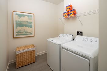 A laundry room with two washing machines and a basket.